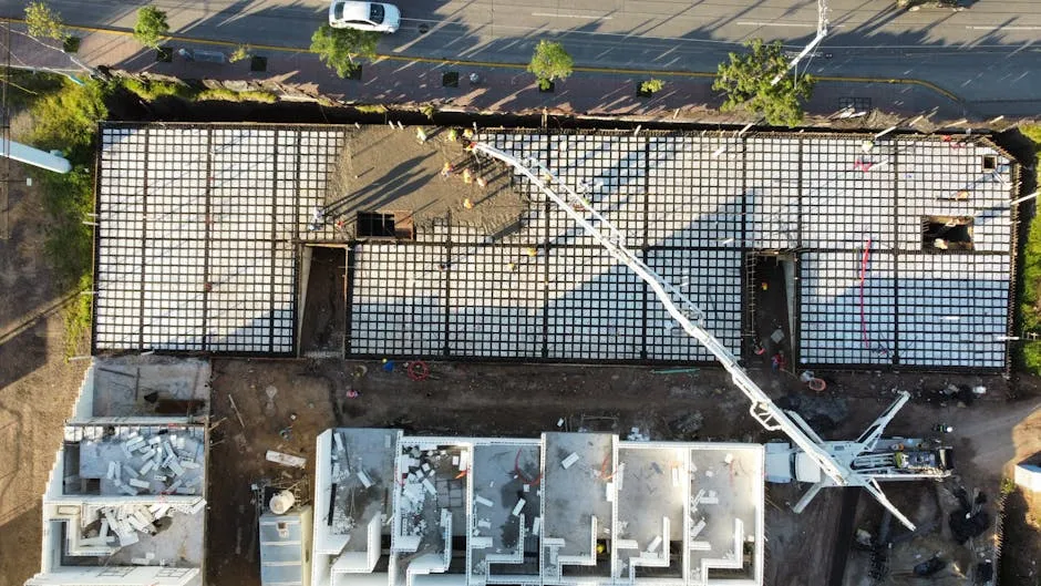 pracownik budowlany wygładzający świeżo wylany beton w szalunkach fundamentowych pracownik budowlany wygładzający świeżo wylany beton w szalunkach fundamentowych